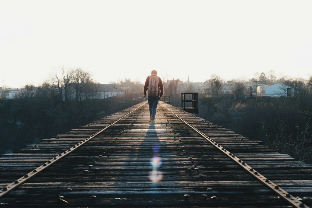 Guy walking on empty train track