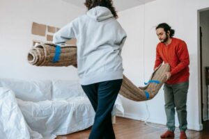 two person transporting a rug 