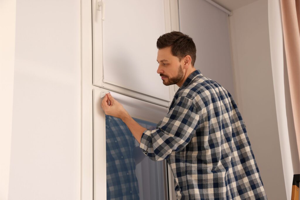 man installing window blind