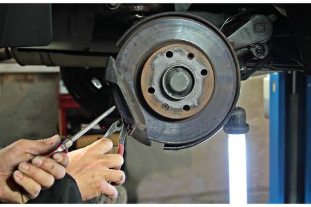 A man removing brake caliper 