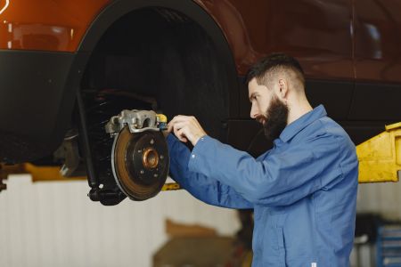 A man re-installing brake caliper 