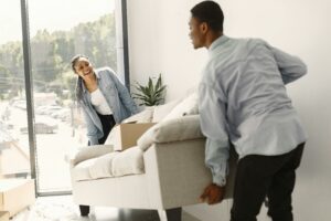 two person moving a couch 