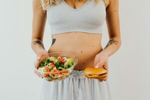 A girl making a choice with a salad or a burger 