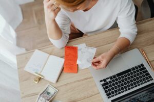 a woman sitting on a desk tracking her spending 